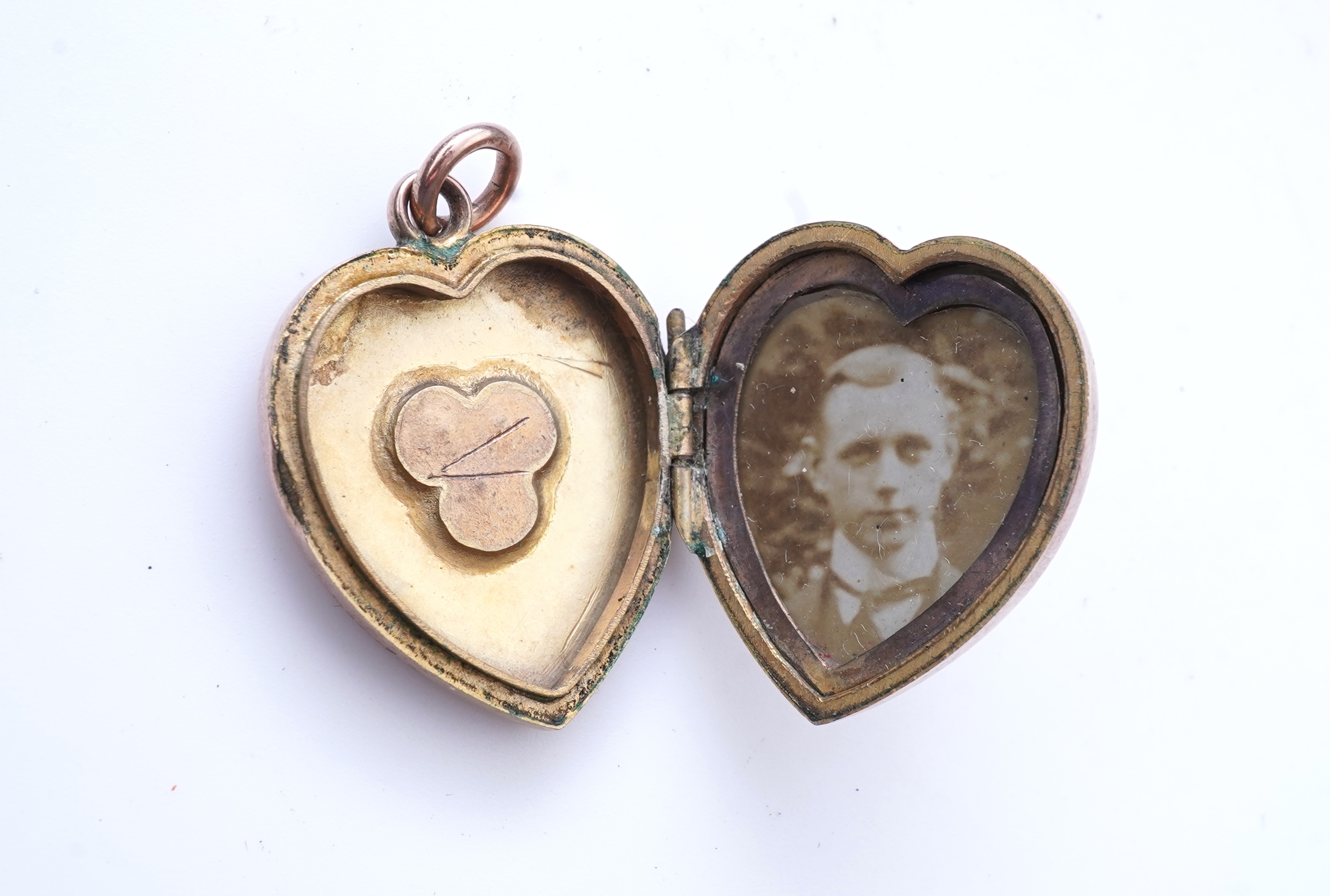 A Victorian yellow metal, amethyst and garnet cluster set brooch, 22mm, an early 20th century yellow metal and seed pearl set heart shaped locket, a yellow metal, garnet and zircon set three stone bar brooch and a tortoi